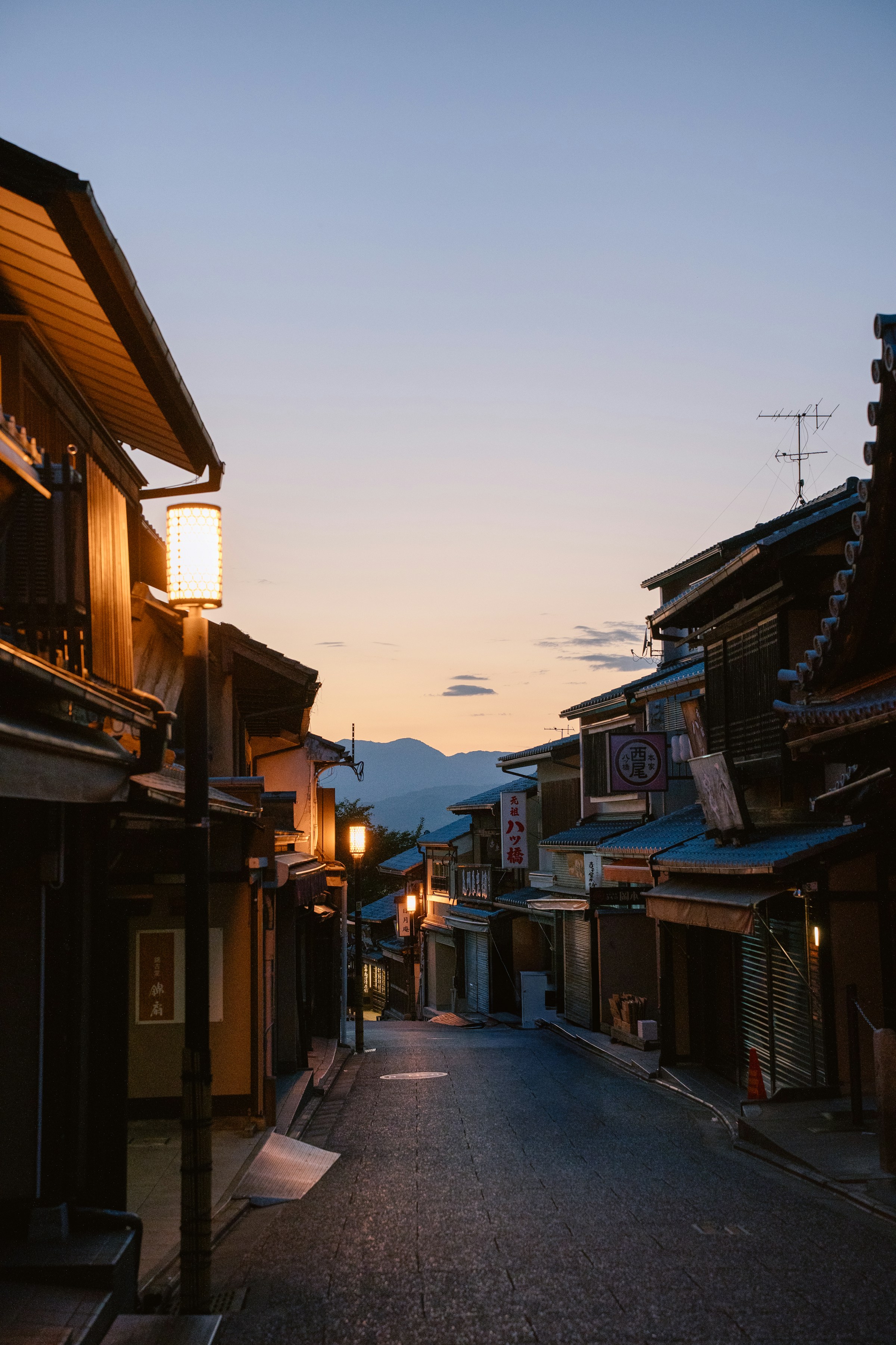 Ruelle traditionnelle de Kyoto éclairée par des lanternes au crépuscule